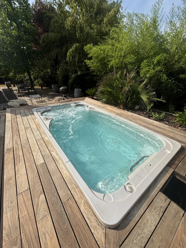 Spa de nage à l'eau claire sur terrasse en bois
