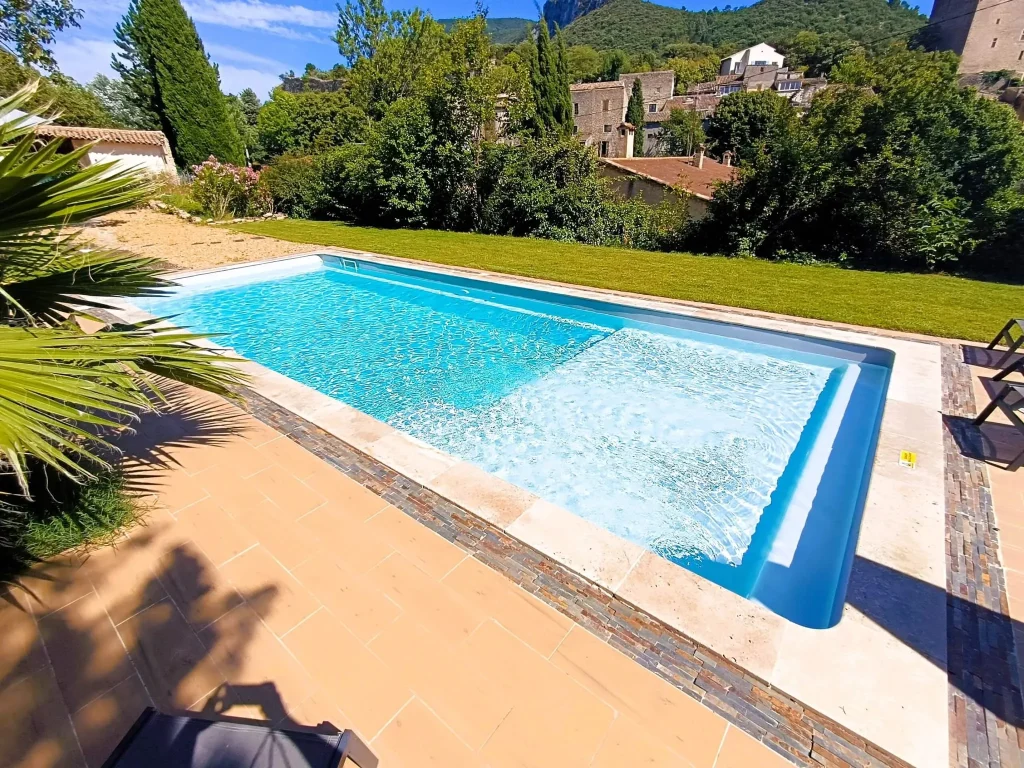 Piscine à volet immergé et margelles en pierre naturelle