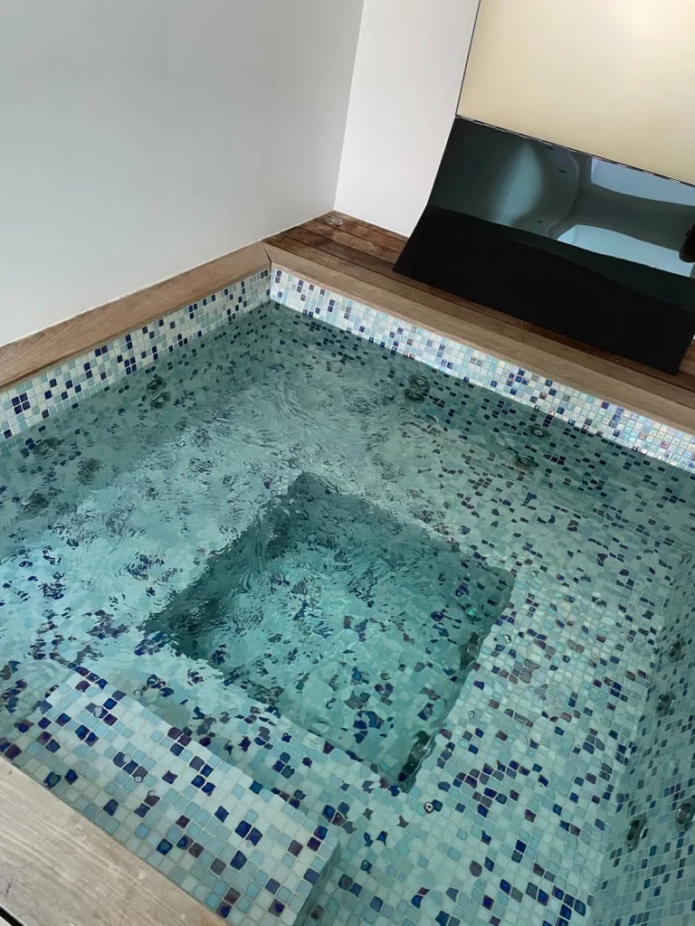 Spa carrelé en mosaïque à l'eau turquoise, entretenu par R2eau